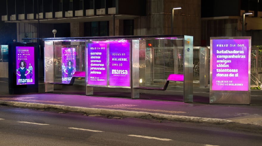 Pontos de ônibus são iluminados com luz magenta em campanha da Marisa